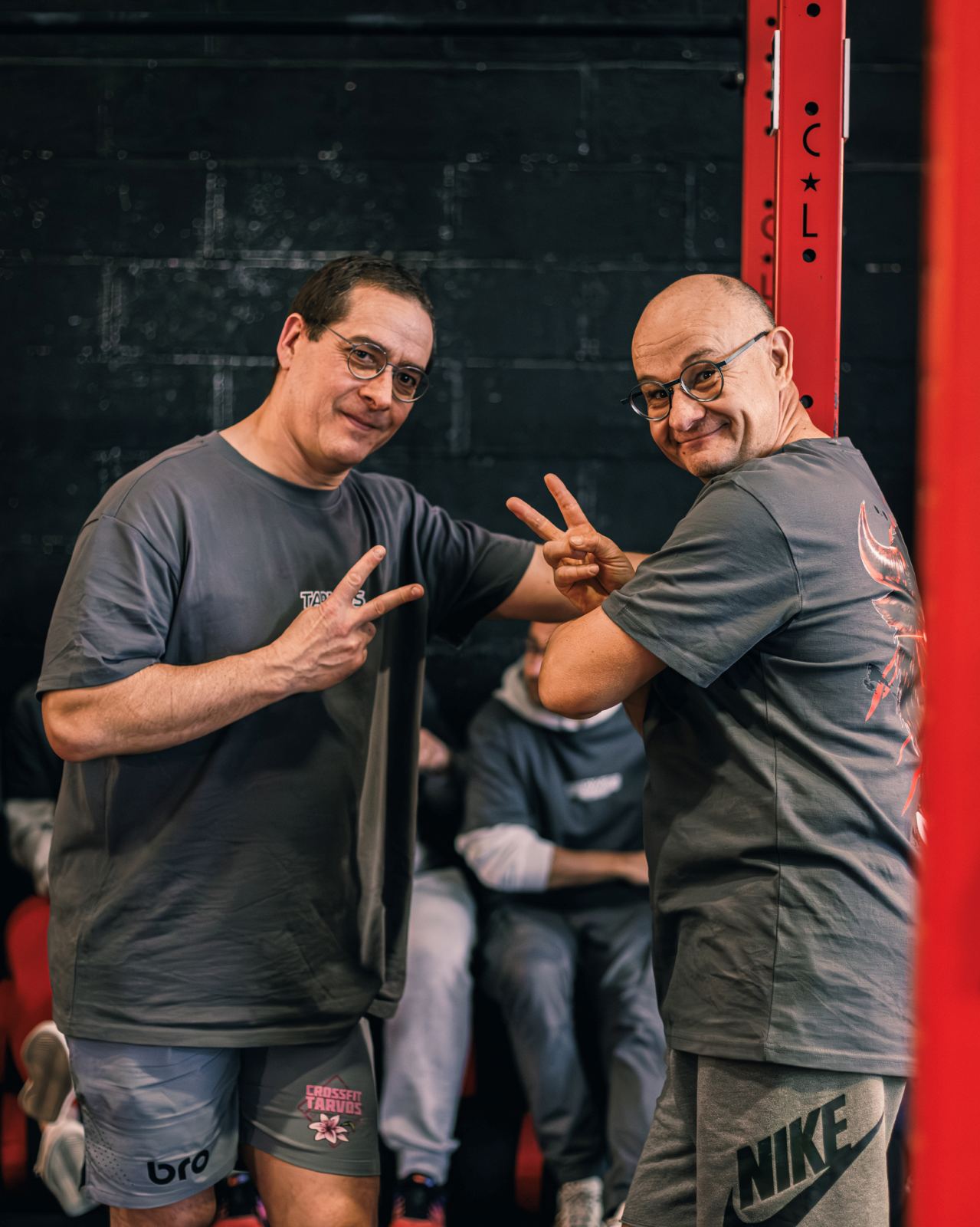Deux membres sourient en faisant le signe V